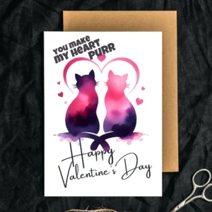 Two watercolor cats in pink and purple sit close together, forming a heart shape with their silhouettes. Text reads "You Make My Heart Purr" and "Happy Valentine's Day".