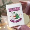 A festive lesbian Christmas card with a polar bear wearing a hat and a colorful Christmas tree, perfect for holiday greetings.