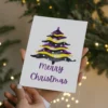 Festive printable card showcasing a watercolor Christmas tree, celebrating nonbinary identity.