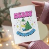 Cute cartoon bear and a colorful Christmas tree on a printable card celebrating pansexuality during the holidays.