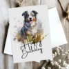 Watercolor birthday card for dogs, depicting an Australian Shepherd in a natural setting, complete with a "Happy Birthday" note.