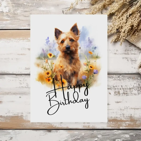 Printable birthday card with a Australian Terrier watercolor illustration in nature, featuring a joyful "Happy Birthday" greeting.