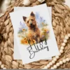 Delightful watercolor birthday card of a Australian Terrier in a natural backdrop, adorned with a "Happy Birthday" note.