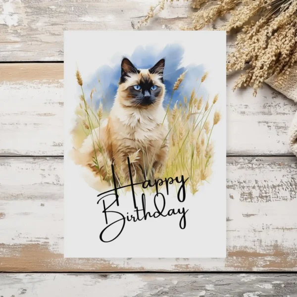 Printable birthday card with a watercolor Balinese cat in a natural setting, adorned with a cheerful "Happy Birthday" greeting.