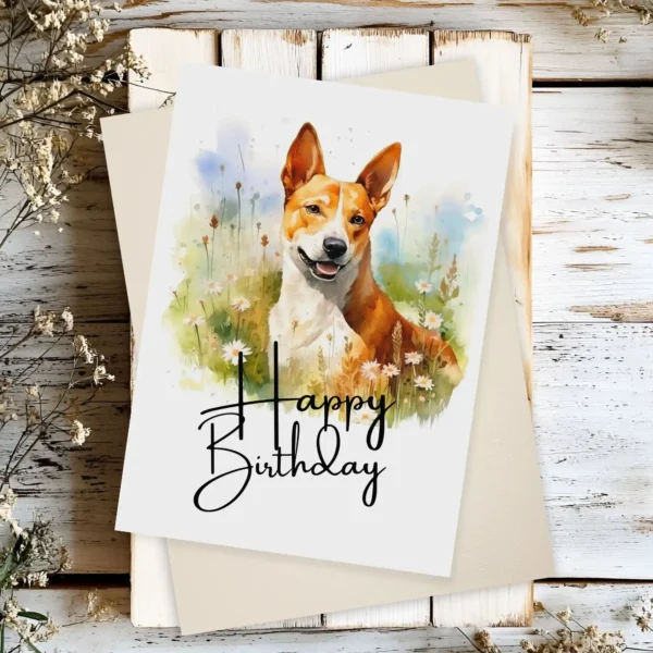 Printable birthday card showcasing a joyful Basenji dog in nature, with a cheerful "Happy Birthday" greeting.