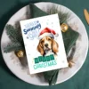 Holiday card featuring a Beagle in red Santa hat with snow and funny message