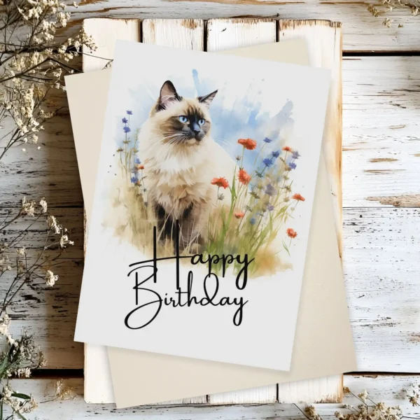 Delightful watercolor illustration of a Birman cat in a natural scene, designed as a birthday card with "Happy Birthday" text.