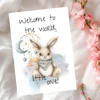 Cute watercolor bunny card with the message "Welcome to the world, little one!" for a new baby celebration.