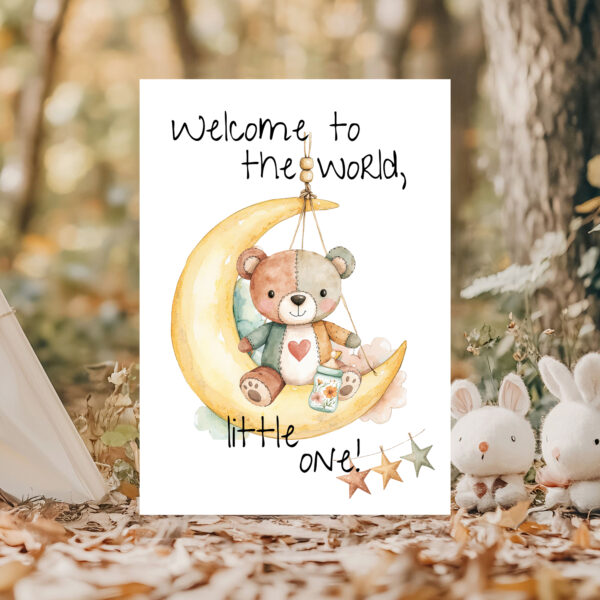 Charming greeting card depicting a teddy bear on the moon, featuring the message, "Welcome to the world, little one!"