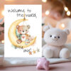 Watercolor greeting card featuring a teddy bear on the moon with the message, "Welcome to the world, little one!"