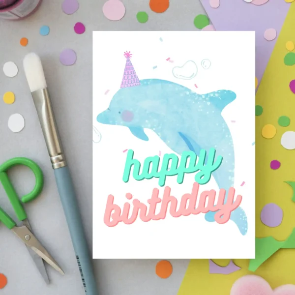 Watercolor dolphin birthday card with dolphin wearing a party hat and “Happy Birthday” message