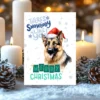 Printable German Shepherd Christmas card with red Santa hat, snowy background, and the message “There’s snowbody like you!”