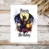 A whimsical birthday card showcasing a purple dragon with a lantern, surrounded by blooming flowers in a gothic style.