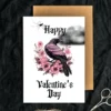 Valentine's Day card with a joyful raven, decorated with pink roses, in a stylish Gothic pink and black theme.