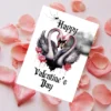 A Valentine's Day card depicting two pink swans whose necks form a heart, with a dreamy cloud scene in the background.