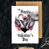 Printable Gothic Valentine's Day card featuring two pink swans forming a heart with their necks against a cloudy background.