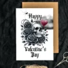 Unique Valentine's Day card with a skull and black roses against a dark cloud, perfect for gothic romance lovers.