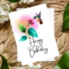 Watercolor birthday card depicting a hummingbird enjoying nectar from a flower, ideal for a cheerful celebration.