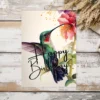 Delightful printable birthday card featuring a green hummingbird and floral accents, designed in watercolor.