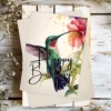 Charming watercolor birthday card showcasing a green hummingbird surrounded by colorful flowers.