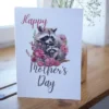 Charming raccoon surrounded by flowers, designed for a printable Mother's Day card to honor moms in a fun way.