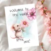 Charming mouse illustration with a pink flower on a card that reads "Welcome to the world, little one!"