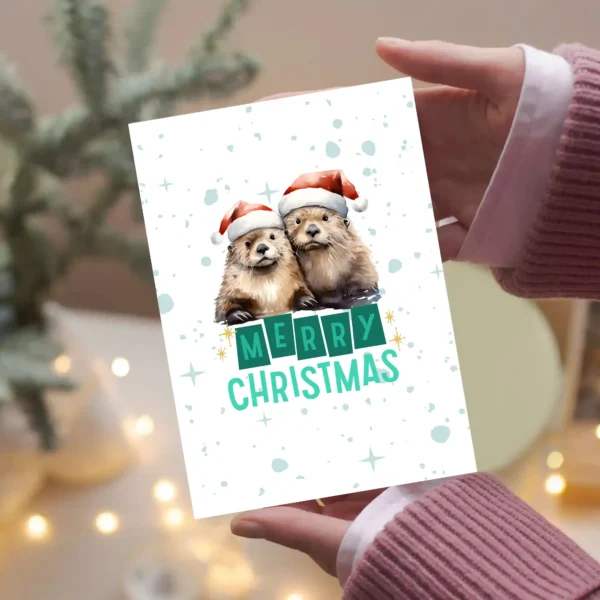 Two cute otters wearing red Santa hats in a snowy scene with the message "Merry Christmas"