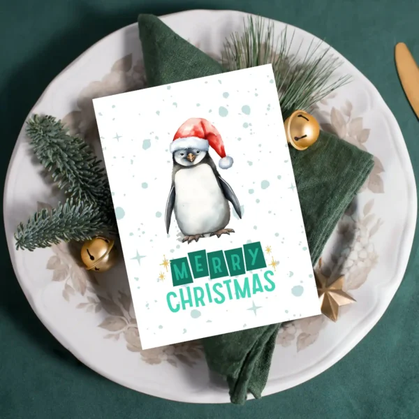 Printable Christmas card featuring a penguin in a Santa hat and snowy background