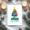 Watercolor rainbow Christmas tree with snow and “Merry Christmas” text