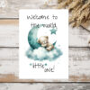 Charming watercolor illustration of a bear on a moon with clouds, featuring the message "Welcome to the world, little one!"