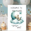 Adorable card with a sleepy bear on a moon, clouds in the background, and the phrase "Welcome to the world, little one!"