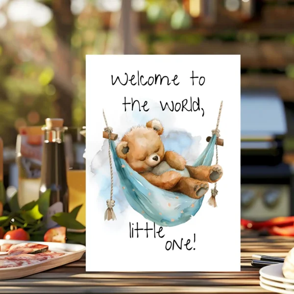 Sweet new baby card with a teddy bear in a blue hammock and the message, "Welcome to the world, little one!" in watercolor.