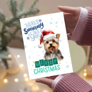 Printable Yorkshire Terrier Christmas card with red Santa hat, snowy background, and the message “There’s snowbody like you!”