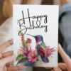 Printable purple hummingbird birthday card featuring watercolor design with flowers. Perfect for celebrating special occasions.