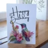 Watercolor birthday card with a purple hummingbird and flowers, ideal for sending warm wishes on someone's special day.