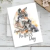 Happy Mother's Day card featuring a watercolor wolf mom with her playful pup, celebrating maternal love.