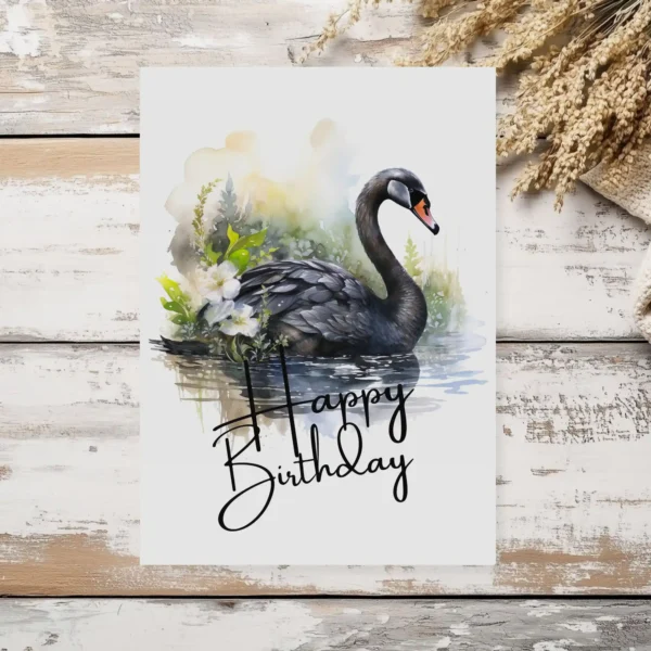 Happy birthday card showcasing a black swan in a serene watercolor scene, complete with a festive "Happy Birthday" text.