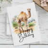 Printable birthday card showcasing a happy camel in a natural landscape, adorned with a "Happy Birthday" message.