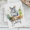 Watercolor birthday card featuring a cheerful chinchilla in a natural setting with a "Happy Birthday" message.