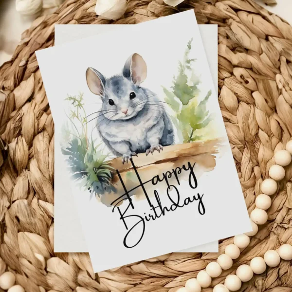 Delightful birthday card featuring a chinchilla in a watercolor landscape, complete with a cheerful "Happy Birthday" message.