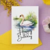 Printable birthday card with a watercolor swan in a serene setting, adorned with a joyful "Happy Birthday" greeting.