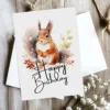 Whimsical birthday card featuring a happy squirrel in a snowy scene, complete with a "Happy Birthday" greeting.