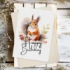 Printable birthday card showcasing a cute squirrel in a watercolor winter landscape with a "Happy Birthday" note.